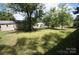Spacious backyard featuring a shed and lush greenery with wildflowers at 402 Villa St, Kannapolis, NC 28083