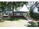 Exterior view of ranch home with ramp and red brick accents surrounded by mature trees in need of TLC at 402 Villa St, Kannapolis, NC 28083