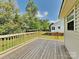 Back deck with a wood railing and lush greenery surrounding the home at 4328 Frank Vance Rd, Charlotte, NC 28216