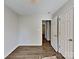 A serene bedroom with neutral walls and wood-look floors leading to an open doorway at 4328 Frank Vance Rd, Charlotte, NC 28216