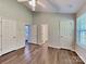 Light-filled bedroom with laminate floors, vaulted ceiling, and access to the bathroom and closet space at 4328 Frank Vance Rd, Charlotte, NC 28216
