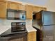 Modern kitchen with black appliances, wood cabinets, and bright countertops at 4328 Frank Vance Rd, Charlotte, NC 28216