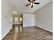 Open living room boasts laminate floors, vaulted ceiling with fan, and natural light filtering through the windows at 4328 Frank Vance Rd, Charlotte, NC 28216