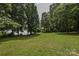 Expansive backyard, framed by lush trees, sloping down to the tranquil lakefront at 4920 Surfwood Dr, Sherrills Ford, NC 28673