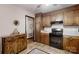 Kitchen features wooden cabinets, black appliances, and an accent rug on tile flooring at 4920 Surfwood Dr, Sherrills Ford, NC 28673