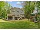 Backyard view of a two-story home with decks, patio, and playset on a large lawn at 5075 Lakeview Cir, Sherrills Ford, NC 28673