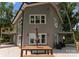 Back exterior with gray siding, large windows, wooden table, and outdoor seating at 5075 Lakeview Cir, Sherrills Ford, NC 28673