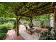 A cozy backyard patio is covered by a vine-covered wooden pergola, offering shade and creating an inviting outdoor living space at 603 S Fulton St, Salisbury, NC 28144