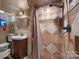 Cozy bathroom featuring unique tile work, a vessel sink, and bronze shower fixtures at 603 S Fulton St, Salisbury, NC 28144