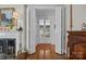 Hallway with hardwood floors, fireplace, and open doors leading to another room at 603 S Fulton St, Salisbury, NC 28144