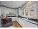 Well-lit kitchen features white cabinetry, dark countertops, and stainless steel appliances at 603 S Fulton St, Salisbury, NC 28144