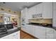 Bright kitchen with white cabinets, black countertops, wine rack, and a double wall-oven at 603 S Fulton St, Salisbury, NC 28144