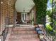 Covered front porch with brick columns, wicker furniture, and charming curb appeal at 603 S Fulton St, Salisbury, NC 28144