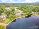 Idyllic aerial view of a lakeside home surrounded by mature trees in a tranquil neighborhood at 6823 Manatee Dr, Concord, NC 28025
