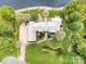 Aerial view of large brick estate home with lush, mature landscaping and private pond at 6823 Manatee Dr, Concord, NC 28025