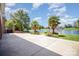 Expansive backyard with palm trees overlooking a serene lake and lush landscaping at 6823 Manatee Dr, Concord, NC 28025