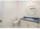 Powder room featuring a marble floor, blue sink, and a round mirror at 6823 Manatee Dr, Concord, NC 28025