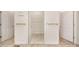 Hallway showing multiple closets, shelving, and tile flooring at 6823 Manatee Dr, Concord, NC 28025
