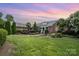Elegant brick residence with manicured lawn, lush landscaping, and charming water feature at 6823 Manatee Dr, Concord, NC 28025