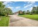 Large driveway leading to a three-car garage, landscaped yard, and brick home exterior at 6823 Manatee Dr, Concord, NC 28025