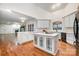 Spacious kitchen with hardwood floors, white cabinetry, marble counters, and kitchen island at 6823 Manatee Dr, Concord, NC 28025