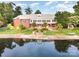 Aerial view showcases the home's lakeside setting, manicured lawns, and private dock at 6823 Manatee Dr, Concord, NC 28025