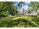 Lush backyard with well-maintained lawn, deck, and mature trees, offering a peaceful and private outdoor space at 6908 Beamish Pl, Mint Hill, NC 28227