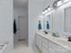 Well lit bathroom with double sink vanity, mirrors, and white tiling at 6908 Beamish Pl, Mint Hill, NC 28227
