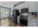 Kitchen boasts stainless steel appliances, white cabinets, and bright window at 6908 Beamish Pl, Mint Hill, NC 28227