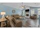 Inviting living room with fireplace, ceiling fan, wood floors, and comfortable brown couches at 6908 Beamish Pl, Mint Hill, NC 28227