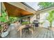 Spacious covered porch features an outdoor dining area, grill, and a cozy seating area at 7901 Bud Henderson Rd, Huntersville, NC 28078