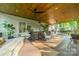 Covered porch with outdoor furniture, heater, tub and wooded views at 7901 Bud Henderson Rd, Huntersville, NC 28078