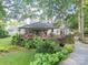Spacious covered porch with lush landscaping and mature trees create a private outdoor living space at 7901 Bud Henderson Rd, Huntersville, NC 28078
