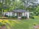 Charming one-story home with brick-lined landscape and a well-manicured lawn nestled among mature trees at 7901 Bud Henderson Rd, Huntersville, NC 28078