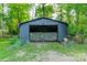A large outdoor storage shed features an open front with a camouflaged barrier, providing secure storage at 7901 Bud Henderson Rd, Huntersville, NC 28078