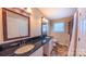 Dual sink bathroom vanity features dark countertops and sleek fixtures adjacent to shower and window at 920 Thomas St, Statesville, NC 28677