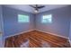 Cozy bedroom featuring sleek ceiling fan, two windows for natural light, and wood-look flooring throughout at 920 Thomas St, Statesville, NC 28677