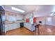Open kitchen featuring white cabinetry, granite countertops, island with seating, and hardwood floors at 920 Thomas St, Statesville, NC 28677