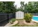 Fenced-in backyard with a shed, lush landscaping, and a partial view of the pool at 1003 Grayscroft Dr, Waxhaw, NC 28173