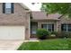 Close-up of a brick home featuring a well-maintained lawn, trimmed bushes, and an attached two-car garage at 1003 Grayscroft Dr, Waxhaw, NC 28173