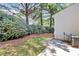 Side yard with AC unit, small concrete block patio, pine trees and green bushes at 10032 Pergola View Ct, Charlotte, NC 28213