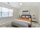 Bedroom with neutral carpet, ceiling fan, large window, bed and modern furniture at 10032 Pergola View Ct, Charlotte, NC 28213