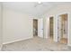 Bright bedroom features neutral carpeting, a ceiling fan, and doors to the ensuite bathroom at 10032 Pergola View Ct, Charlotte, NC 28213