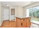 Kitchen island with storage and granite countertop next to sliding glass doors and laundry room at 10032 Pergola View Ct, Charlotte, NC 28213