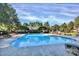 Large community swimming pool surrounded by trees, lounge chairs, and clear blue skies at 10032 Pergola View Ct, Charlotte, NC 28213