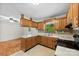 A kitchen showcasing wooden cabinets, a black stove, a white countertop, and view to another room at 1156 Westover Cir, Rock Hill, SC 29732