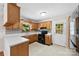 A kitchen showcasing wooden cabinets, a black stove, a white countertop, and an exterior door to the backyard at 1156 Westover Cir, Rock Hill, SC 29732