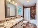 Well lit bathroom with a large framed mirror and tile counters and shower at 1175 18Th Ne Ave, Hickory, NC 28601