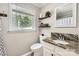 Well-lit bathroom featuring a granite vanity, toilet, and window at 1175 18Th Ne Ave, Hickory, NC 28601