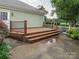 View of the home's wood deck and a view of the landscaped backyard beyond a short fence at 13604 Morehouse St, Huntersville, NC 28078